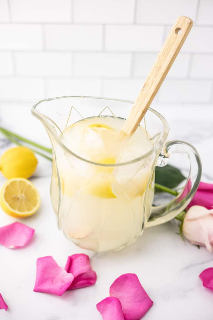 Vanilla bean rose lemonade in a pitchure with roses and lemons